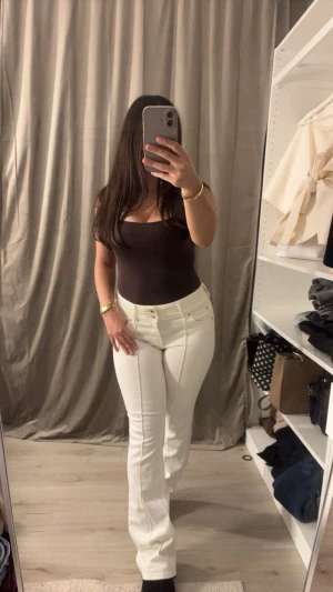 Vita bootcut jeans från Bershka - Snygga vita jeans från Bershka i bootcut-modell med medel höjd på midjan och klassiska fem fickor. Jeansen har en stilren look med raka ben. Perfekta för dig som gillar en clean och fräsch stil.