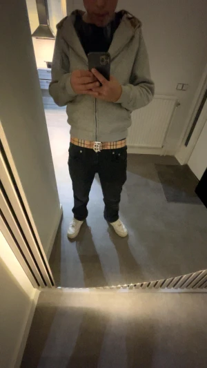 Burberry bälte med TB-spänne - Säljer ett Burberry bälte med stort TB-monogram i silverfärgad metall. Bältet har klassiskt rutigt mönster i beige, brunt och svart samt en variant i svart och grått. Perfekt accessoar för att lyfta din outfit med en lyxig touch.