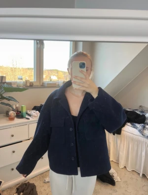 Mörkblå overshirt från LeGer - Säljer en mörkblå overshirt från LeGer med klassisk krage, stora bröstfickor och knappar framtill. Jackan har en loose passform och är långärmad, perfekt för lager-på-lager. Materialet är ullblandning som ger en mjuk och varm känsla.