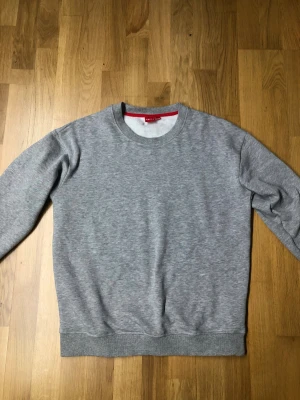 Grå sweatshirt från RYVLS - En enkel och clean grå sweatshirt från RYVLS i storlek 170/176. Tröjan har rund hals, ribbade muddar och är helfärgad utan mönster eller tryck. Perfekt för chill dagar och passar till allt. Mjuk insida och klassisk passform. Tröjan är helt ny aldrig använd endast testad på, säljer pga att jag inte gillade den👌🏻