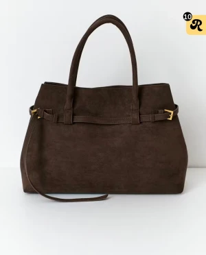 Brun mocka handväska med axelrem - Snygg handväska i mörkbrun mocka med stilren form och guldfärgade detaljer. Väskan har både handtag och en avtagbar axelrem, perfekt för att bära på olika sätt. Enkel design med dekorativt spänne på sidan som ger en exklusiv känsla.