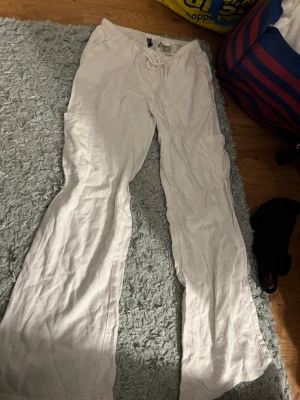 Vita linnebyxor från H&M Divided XS - Säljer ett par vita linnebyxor från H&M Divided i storlek XS. Byxorna har snörning i midjan, raka ben och praktiska fickor på sidorna. Perfekta för chill dagar och har en skön loose passform. Materialet är linne som ger en lätt och luftig känsla.🤍🤍