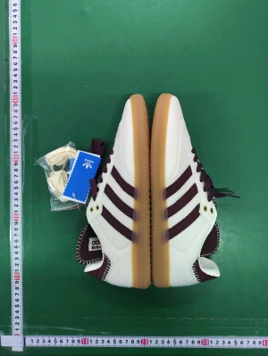 Adidas Samba Wales Bonner vinröd/vit - Adidas Samba Wales Bonner sneakers i vinrött och vitt med klassiska tre ränder på sidan. Ovandel i mocka och skinn, detaljerad med grova sömmar och gummisula. Kommer med extra skosnören. Snygg retrostil och låg profil.