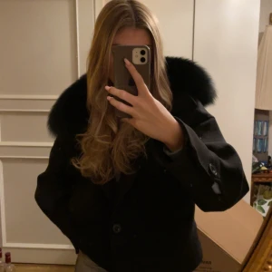 Meotine - Säljer min svarta Meotine Tweed Jacket med äkta blue fox päls på kragen. Perfekt för dig som vill ha en trendig look under de kallare månaderna. 