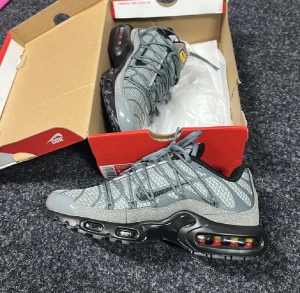 Grå Nike Air Max sneakers - Säljer ett par grå Nike Air Max sneakers med svarta detaljer och synlig luftdämpning i sulan. Skorna har snörning och en sportig design med mesh och syntetmaterial.  Oanvända passar inte mig!