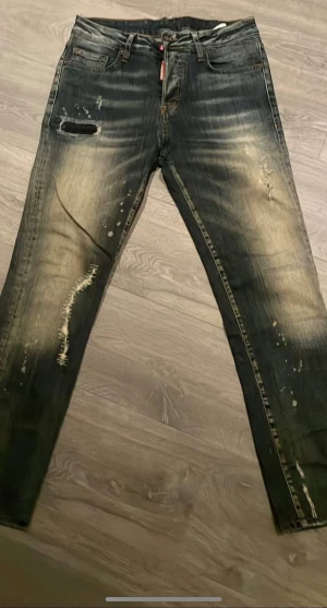 Dsquared2 jeans - Snygga jeans från Dsquared2 med slitna detaljer, blekta partier och coola revor. Klassisk femficksmodell med orange sömmar och Dsquared2-logga vid gylfen. Jeansen har en rak passform och är tillverkade i jeansmaterial.
