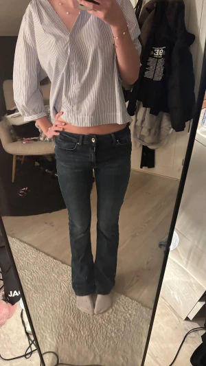 Mörkblå bootcut jeans från only - Snygga mörkblå jeans från only med klassisk bootcut passform. Jeansen har låg midja, fem fickor och en diskret tvättad look. Perfekt för dig som gillar en tidlös stil med lite extra edge. Materialet är slitstarkt denim och de stängs med dragkedja och knapp. Jag är 170