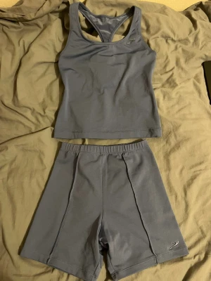 Grå träningsset - Snyggt grått träningsset. Materialet är mjukt och stretchigt polyester som passar perfekt för gymmet och tillochmed simning. 