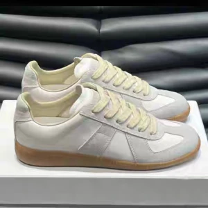 Maison Margiela Skor – Stilrena & Unika - Maison Margiela sneakers i vitt med beige detaljer och ljusbrun sula. Låg modell med snörning och en ren, enkel design. Skinn och mocka gör att skorna får en snygg kontrast. Passar till det mesta och ger en stilren look. Jag fick dem i present men tyvärr var dem för små. 