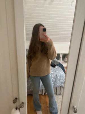 Ljusblå bootcut jeans låg midja - Säljer ett par ljusblå jeans med bootcut passform och låg midja. Jeansen har klassisk femficksdesign, knapp och dragkedja framtill. Materialet är jeans med en mjuk känsla och snygg tvätt. Perfekt för dig som gillar retrovibbar och vill ha en cool siluett.