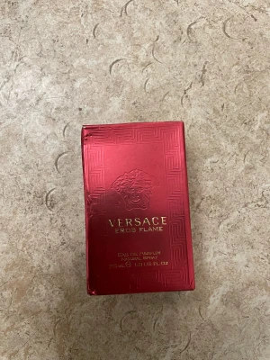 Versace Eros Flame 30ml Parfym - Versace Eros Flame Eau de Parfum, 30 ml. Snygg röd förpackning med lyxig känsla. Tillverkad i Italien. Perfekt storlek att ta med i väskan. Ingredienser finns listade på baksidan av förpackningen.