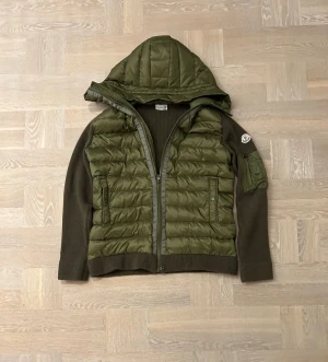 Olivgrön cardigan från Moncler - Säljer nu en Snygg olivgrön cardigan från Moncler med stickade ärmar och quiltad kropp. Anledning till att jag säljer den är att den är för stor och jag är sugen på annat. Släng gärna ett meddelande om ni är sugna😆🤙. Pris kan diskuteras vid snabb affär😁