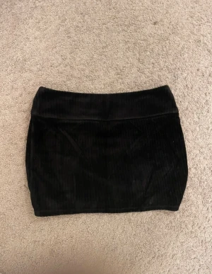 Svart minikjol i mocka material - Tunn minikjol i storlek S. 