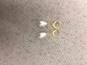Guldörhängen med vita pärlor - Snygga örhängen med droppformade vita pärlor och guldfärgade ringar. Perfekt för dig som vill ha en elegant och stilren accessoar som sticker ut lite extra. Pärlorna har en fin glans och gulddetaljerna ger en lyxig känsla.