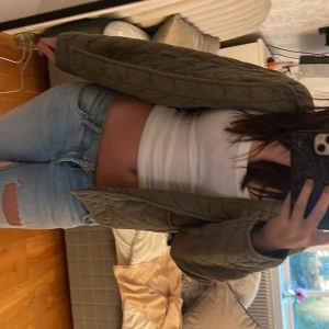 Olivgrön quiltad jacka med knappar - Säljer en olivgrön quiltad höst/vår jacka från Next. Super fin med vågigt mönster dock saknar den en knapp fram till men inget man lägger märke till.