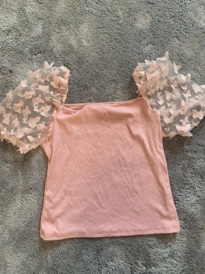 Topp med fjärilar - Jätte fin rosa topp med fjärilar, nästan aldrig använd. Inga fläckar eller defekter. Passar perfekt till våren/sommaren🌸🌼storlek M