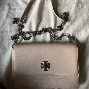 Tory Burch väska - En fin Tory Burch väska i babyrosa. Väskan är oanvänd, tyvärr inte kommit till användning. Modellen görs inte längre och köptes för 3500. Mitt pris är 2000, kan tänkas att diskutera vid snabbaffär. 