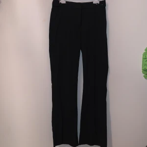 Kostymbyxor - Kritstrecksrandiga kostymbyxor, sprättat upp sömmen längs ned för att göra dem lite längre