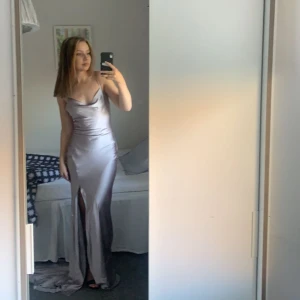 Balklänning - En superfin silver/lila balklänning med släp och öppen rygg. Sitter jättebra på mig som är ungefär 1,65💕 Köpt för 1000kr! Säljer för 500kr, köparen står för frakten! 