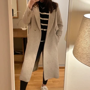 Ull, Kappa, Beige FRAKT INGÅR - Beige ullkappa från H&M. Använt en del men inga tydliga defekter eller fläckar. Varm och go, en favorit i garderoben, men tyvärr blivit för liten. Storlek 38, men skulle säga att den passar en 36:a mer. Jag är 176 cm lång, aningen aningen kort i ärmarna och tajt runt överarmen på mig. Så någon runt 160-170cm tror jag kommer bära den GRYMT SNYGGT! Frakt ingår!
