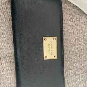 Michael kors plånbok  - Svart Michael Kors plånbok med guld märke. 