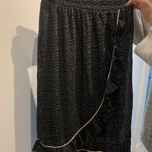 Kjol från nakd  - Svart kjol med vita prickar från nakd. Använd ett fåtal gånger. Storlek 34 men passar mig som brukar ha 36, strechtig resår i midjan.