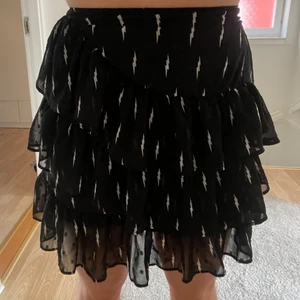 Volangkjol m blixtar - Säljer min jättefina svarta volangkjol med blixtar på. Köpt förra sommaren på boozt men har knappt kommit t användning. Köparen står för frakten 
