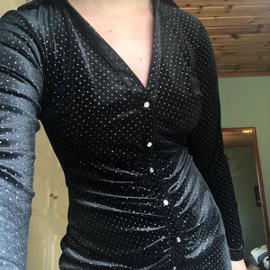 Klänning  - Klänning i velourliknande material med skimrande prickar. Säljer pga för kort för mig är ca 174 cm. Aldrig använd! Orginal pris 399kr