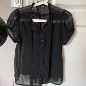 Söt svart blus!  - Gothic svart blus perfekt för sommaren! Tunt genomskinligt material med svarta prickar på och knytdetalj! 