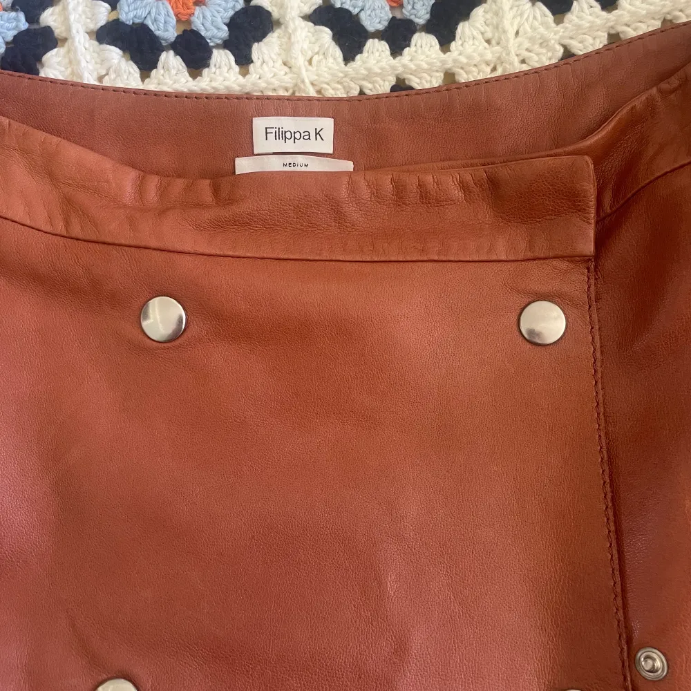 Kjol från Filippa K, modell Leather Wrap Skirt. Använd, men utan anmärkning.  Storlek: Medium Material: Skinn. Kjolar.