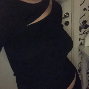 Svart Topp med ett cut vid brösten XS - Snygg svart topp från nelly som bara använts ett fåtal ggr, tröjan är i bra skick!💕