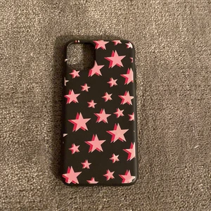 Mobilskal med stjärnor - Säljer detta svarta mobilskal för iPhone 11 PRO med rosa stjärnor då jag råkat köpa fel storlek, köpt här på Plick! Hör av er om ni är intresserade!