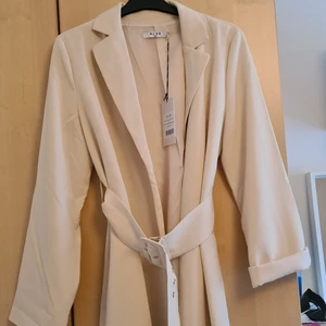 Kappa - Väldigt fin kappa från NA-KD som ej har kommit till någon användning. Lappen finns kvar, storlek 36 men passar en 38 också. Köparen står för frakten