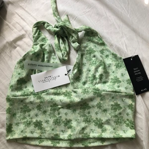 grön topp - säljer denna gröna blommiga toppen, nakd misslissbells kollektion. Aldrig använd & prislapp finns kvar. Tröjan är i storlek 36 men har justerbara band runt nacken. Säljer toppen för 150kr + frakt! 