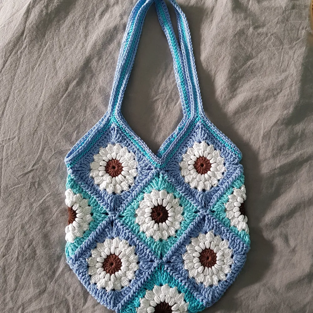 Granny square väska gjord i bomullsgarn💎 Superfin och perfekt på sommaren🌸 Väskan är ca 30 cm i bredd och ca 32 cm i längd. Räknar man med axelremmen är väskan 55 cm i längd totalt. (Normallång axelremm)🌸Frakt ej inräknad i piset🌼. Väskor.