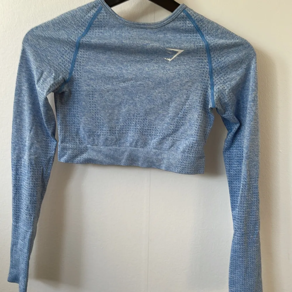 Blå cropped long sleeve från gymshark! Strolek S. Har hål för tummarna. Knappt använd då den varit för liten!🦋 . Toppar.