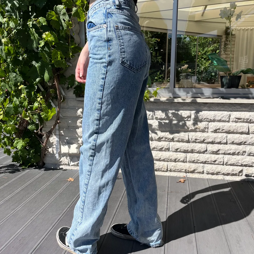 Blå jeans ifårn NA-KD med slitningar nedtill. Bra skick. Passar någon som är runt 165cm lång om man vill att dom ska sitta som på bilden! Köparen står för frakten🫶🏻. Jeans & Byxor.