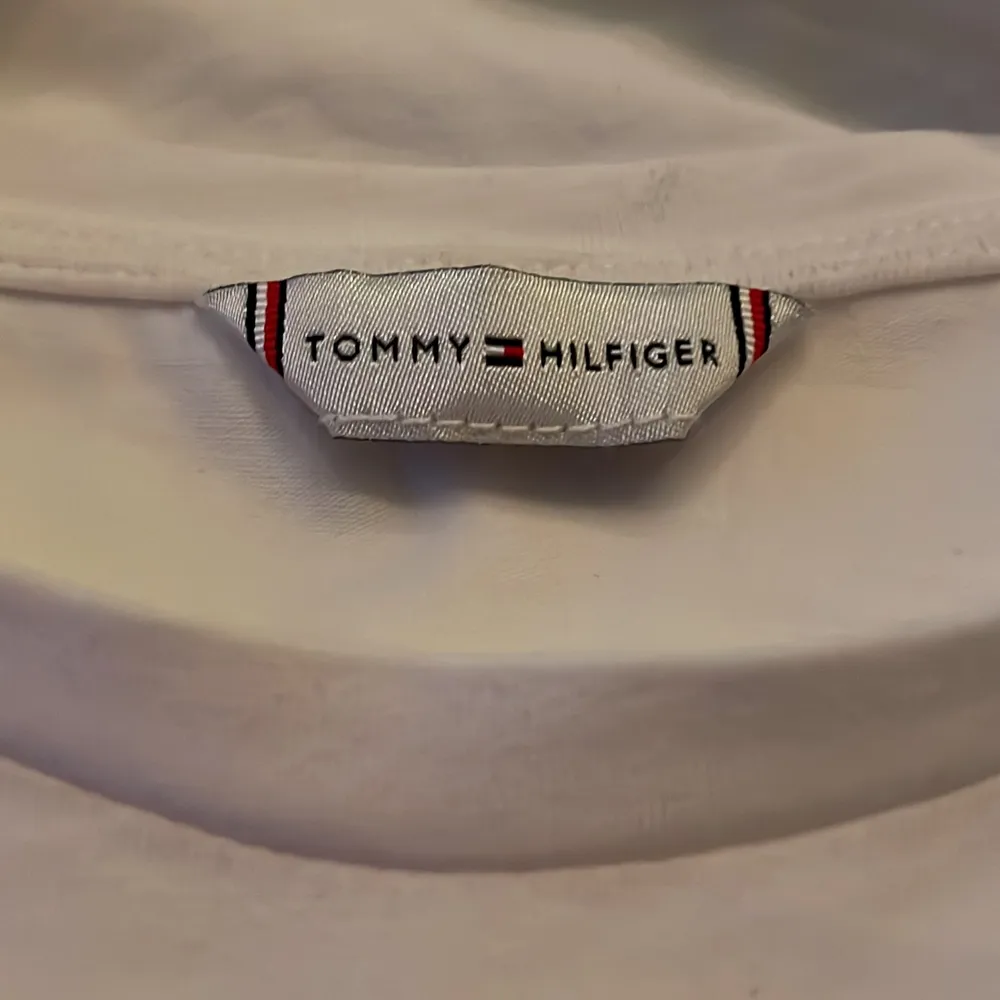 En Äkta vit Tommy Hilfiger t-shirt, helt oandvänd, inga fläckar, äkta märke och i storlek xxs men funkar för XS🤍säljer denna eftersom att jag rensar min garderob och har helt enkelt inte plats för den, orginal pris är 499 kr men säljer för 189 kr 🤍. T-shirts.