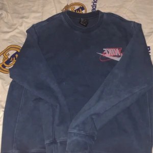 mörkblå Nike sweatshirt - mörkblå nike sweatshirt med snygg detalj på själva tyget, använd ganska mycket, inte längre min stil, har varit i garderoben 1 år orörd, inga flaws.