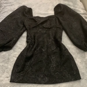 Svart fest klänning - En svart fin klänning med ett ros-mönster. Passar inte mig därav säljer den. Nyskick! Köpare står för frakt. 