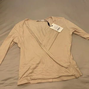Na kd  - Topp från NAKD med urring. Den är baby pink i verkligheten. Storlek M aldrig använd.