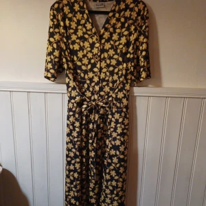 Vintage klänning - Passar M-XL genom midjebandet som knyts.