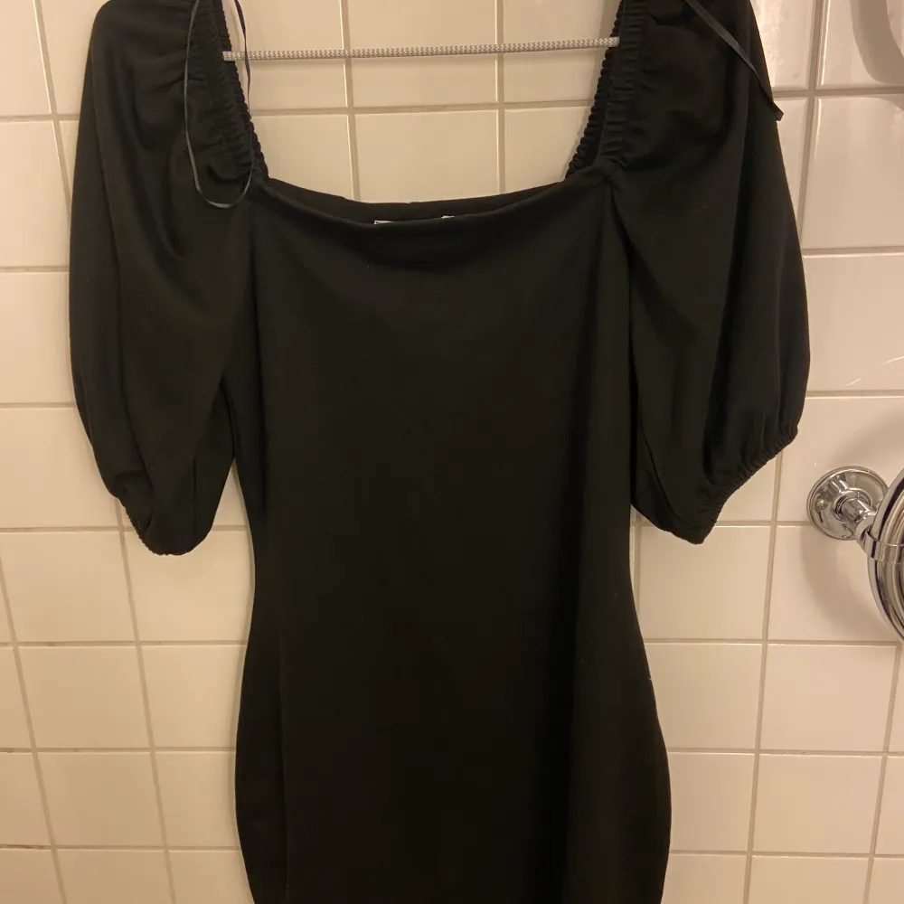 Säljer en svart klänning från NA-KD då den tyvärr inte kommer till användning så ofta. Helt oanvänd. 🤍. Klänningar.