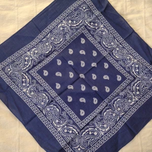 Oanvänd blå y2k scarf/sjal/bandana - Paisley - 100% bomull - Blå oanvänd mönstrad scarf. Paisleymönster. 100% bomull. Drygt 55x55 cm stor. "Köp nu", annars är fraktpriset 22 kr.