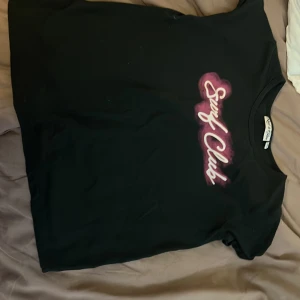 svart tröja med rosa och vit text - en super mysig och fin tröja köpte den för 60kr och säljer den för 30kr köp den nuuuuuuu om ni vill  den är slut i alla butiker 