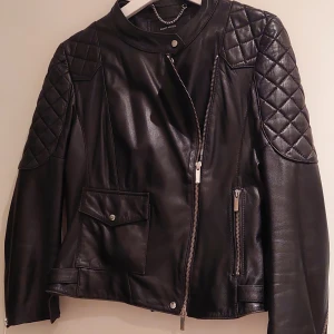 Svart skinnjacka  - Svart skinnjacka, 100 % lamb leather. Hel och fräsch, några diskreta slitningar på skinn. Helt innerfoder. Passar strl 38 mer än 40.