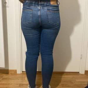Mörkblå jeans från Zara - Ett par mörkblåa jeans med hål från Zara som är jättebekväma och stretchiga men säljs pga att de inte kommer till användning. De är strl 34 men väldigt stretchiga och hade passat någon med strl 36 oxå!!
