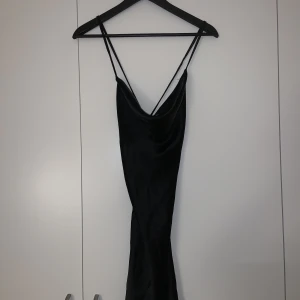 Svart klänning - Svart klänning i mjukt silkes liknande material, storlek XS.  Aldrig använd, fint skick