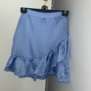 Oanvänd minikjol - Kort glansig minikjol i storlek xs, från pure friday. Köpt i affären Kings & Queens.  Aldrig använd. 