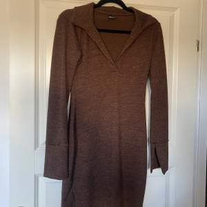 Fin brun klänning från ginatricot med slits i ärmarna. Helt oanvänd. 